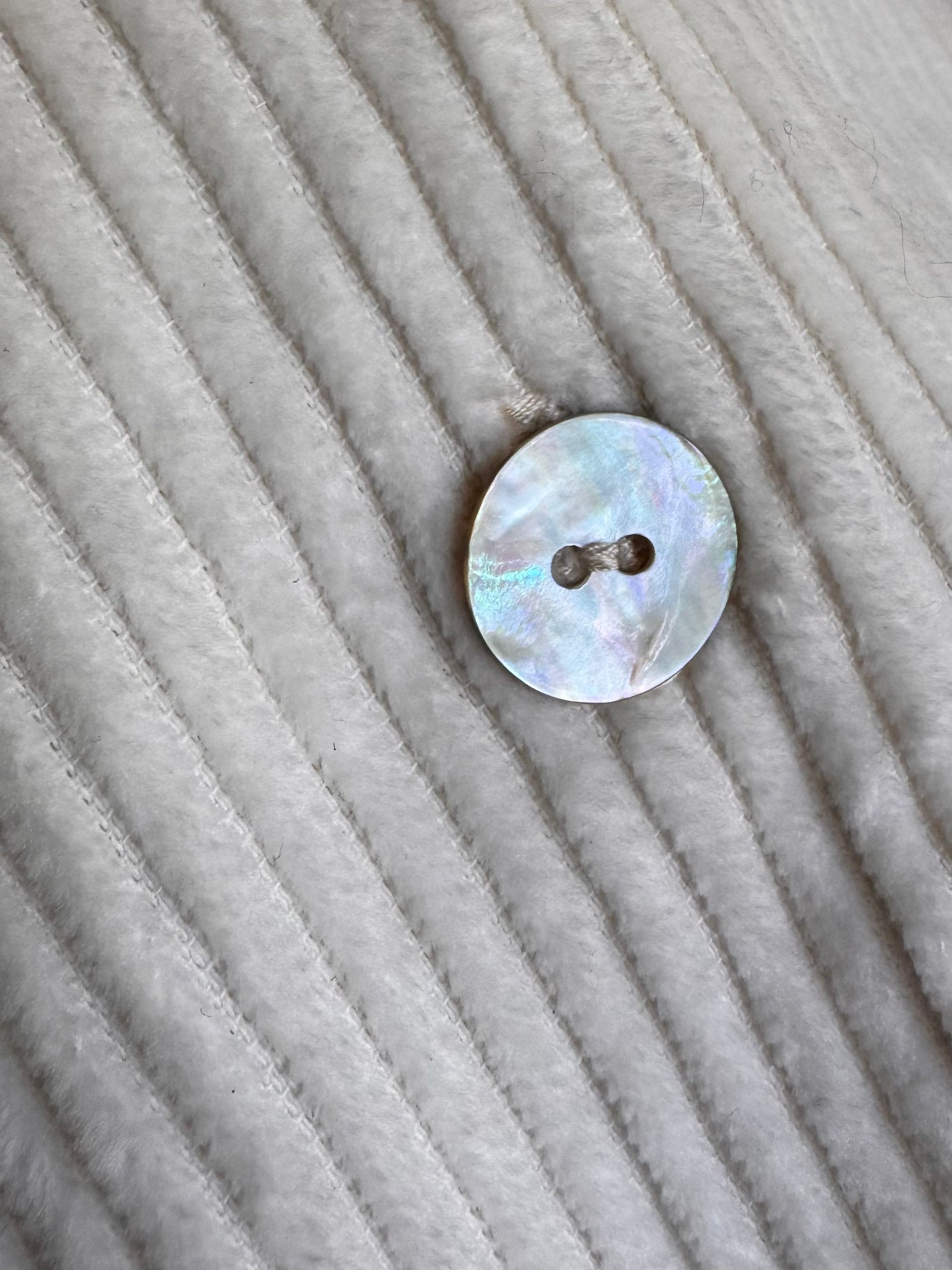 Détail bouton en nacre gilet ivoire sans manche