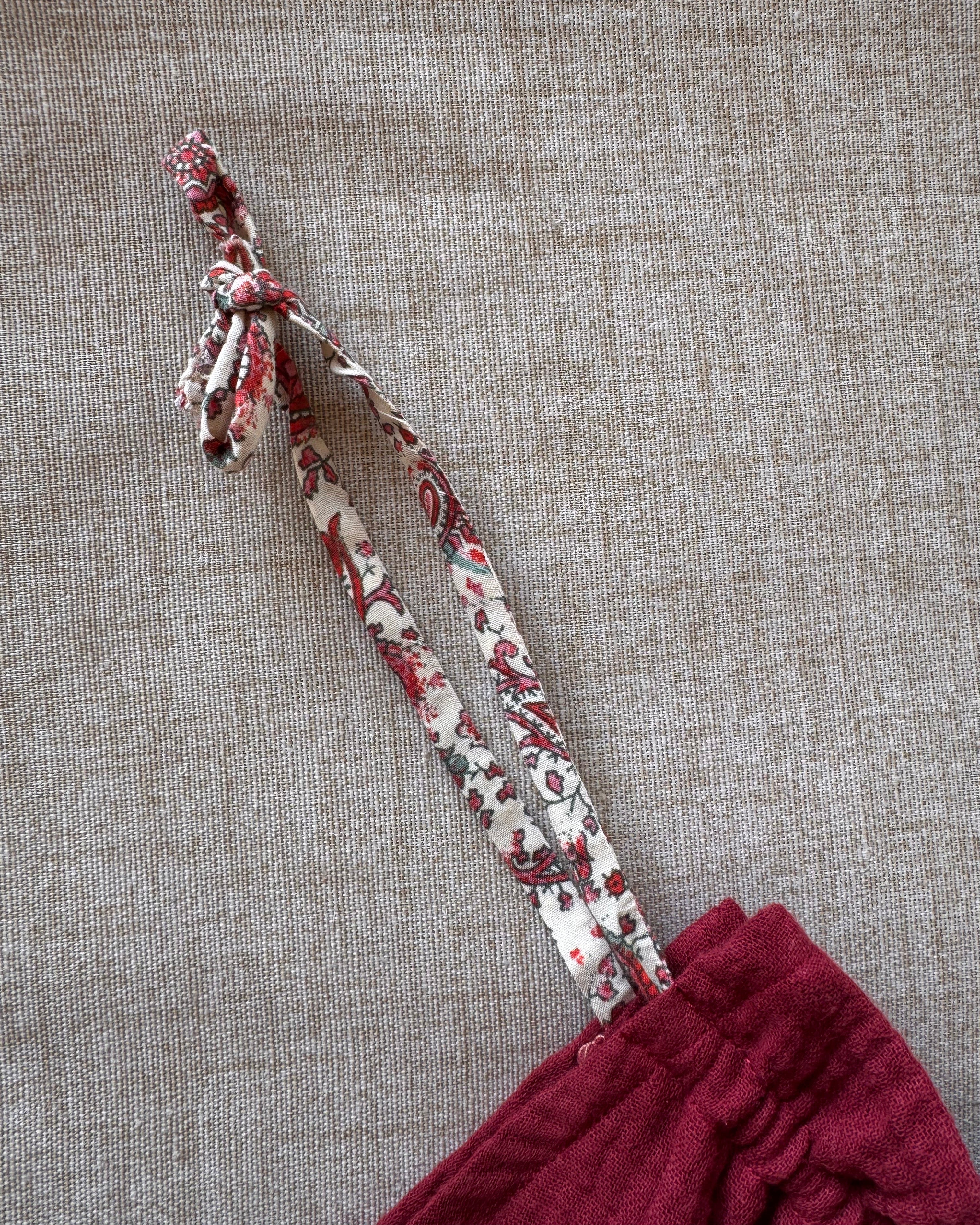 Detail bretelle sur robe lie de vin