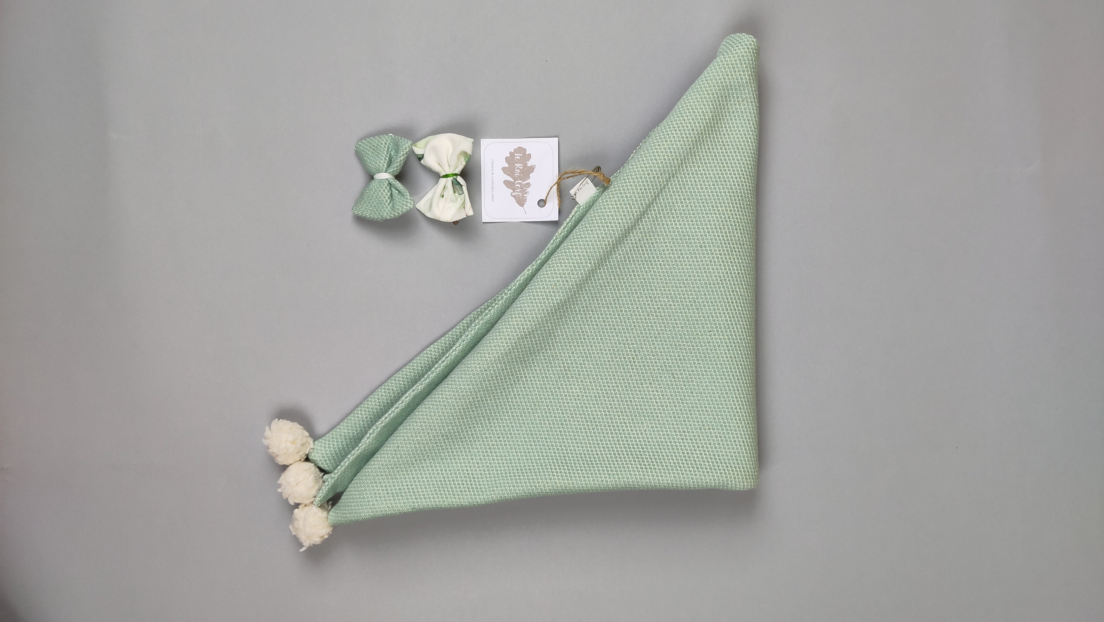 Echarpe couleur celadon a pompons pliée