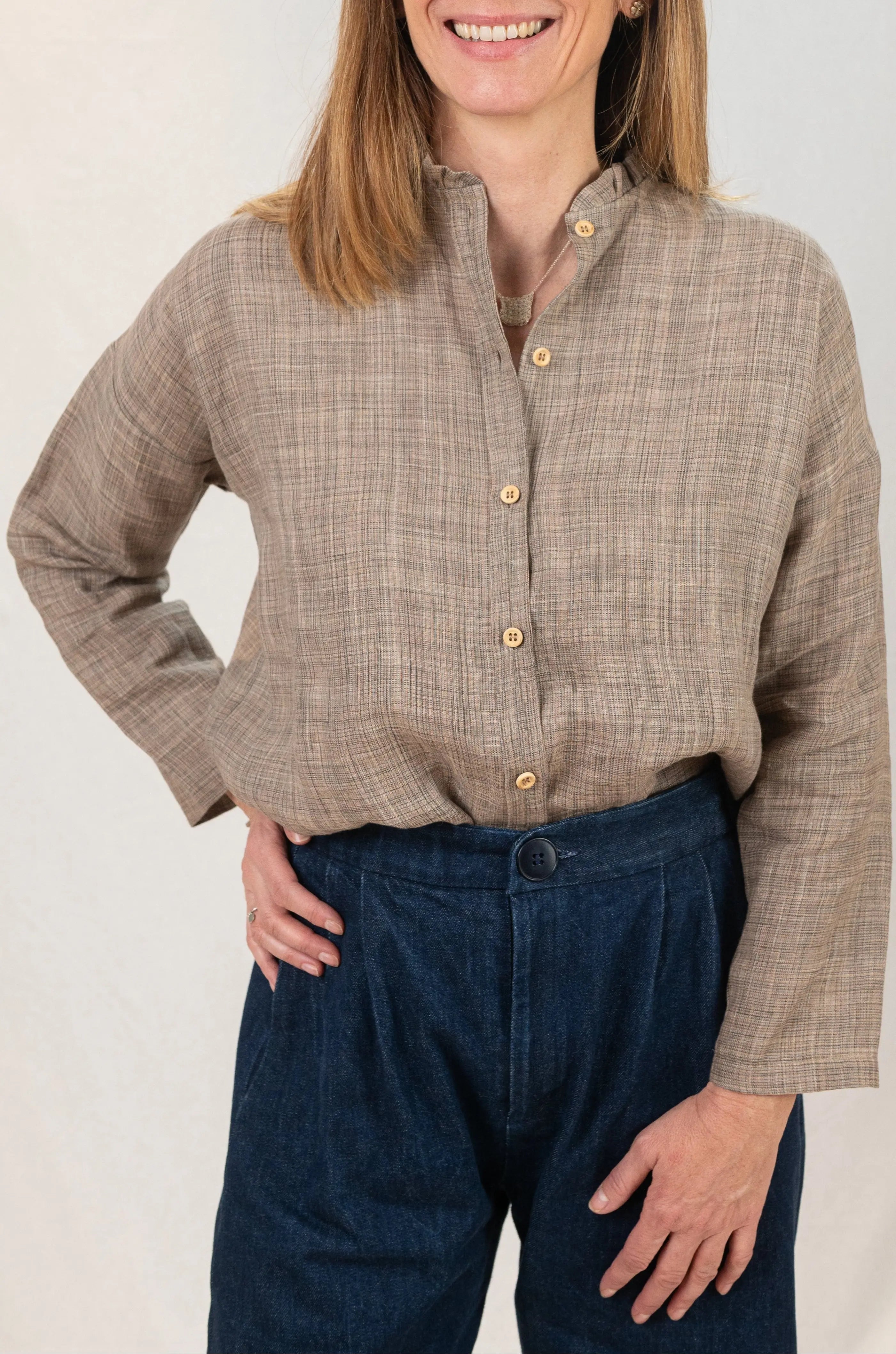 Chemise Narcisse à col froncé en lin couleur grège naturel, détail du col et des boutons en bois, portée avec un collier signé A.no.