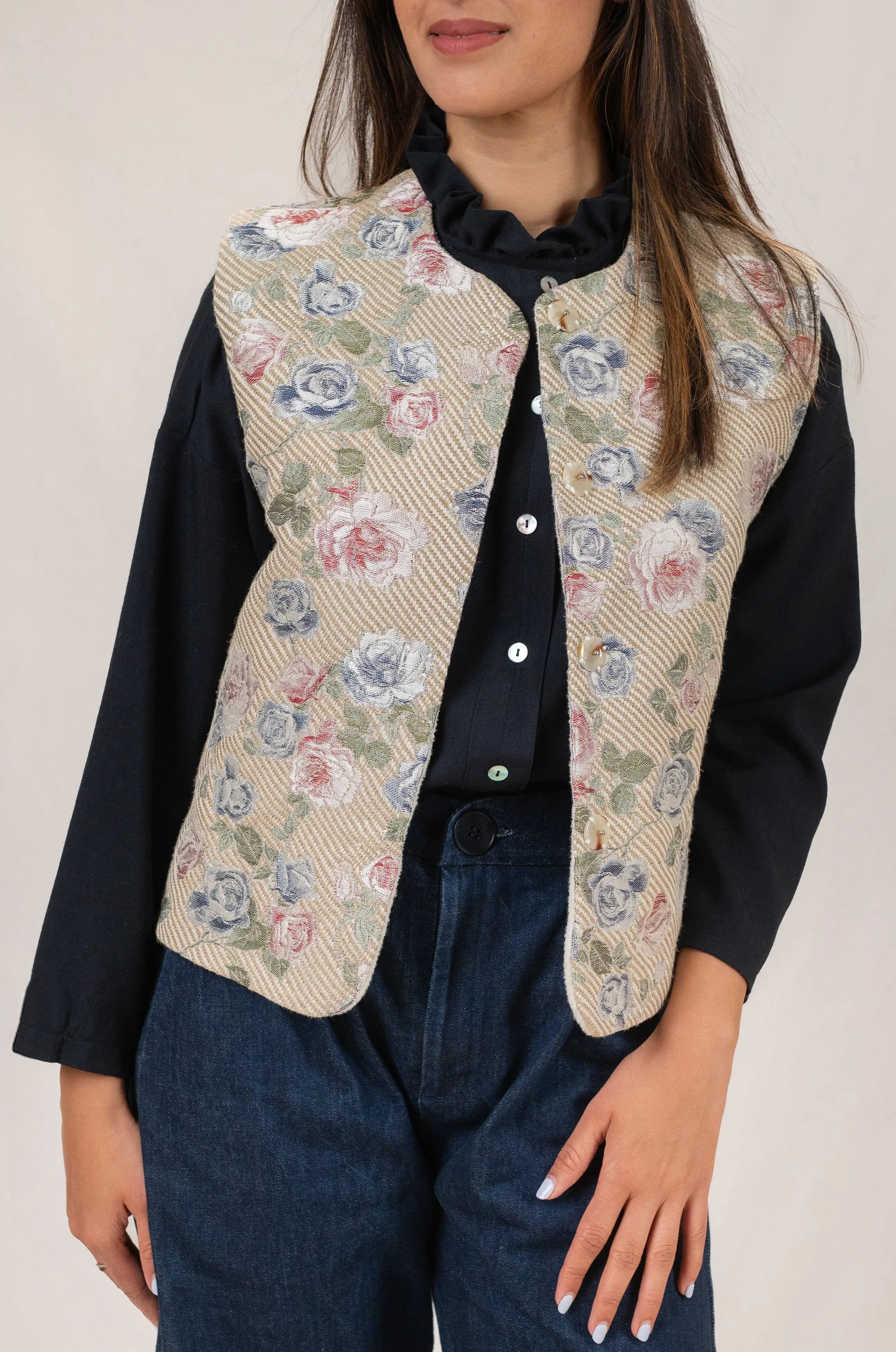 Gilet sans manches Ouessant en jacquard fleuri, vu de face, porté avec une chemise Narcisse en étamine de laine bleu marine et un pantalon Sylène en denim bleu foncé, coupe Barrel Leg.