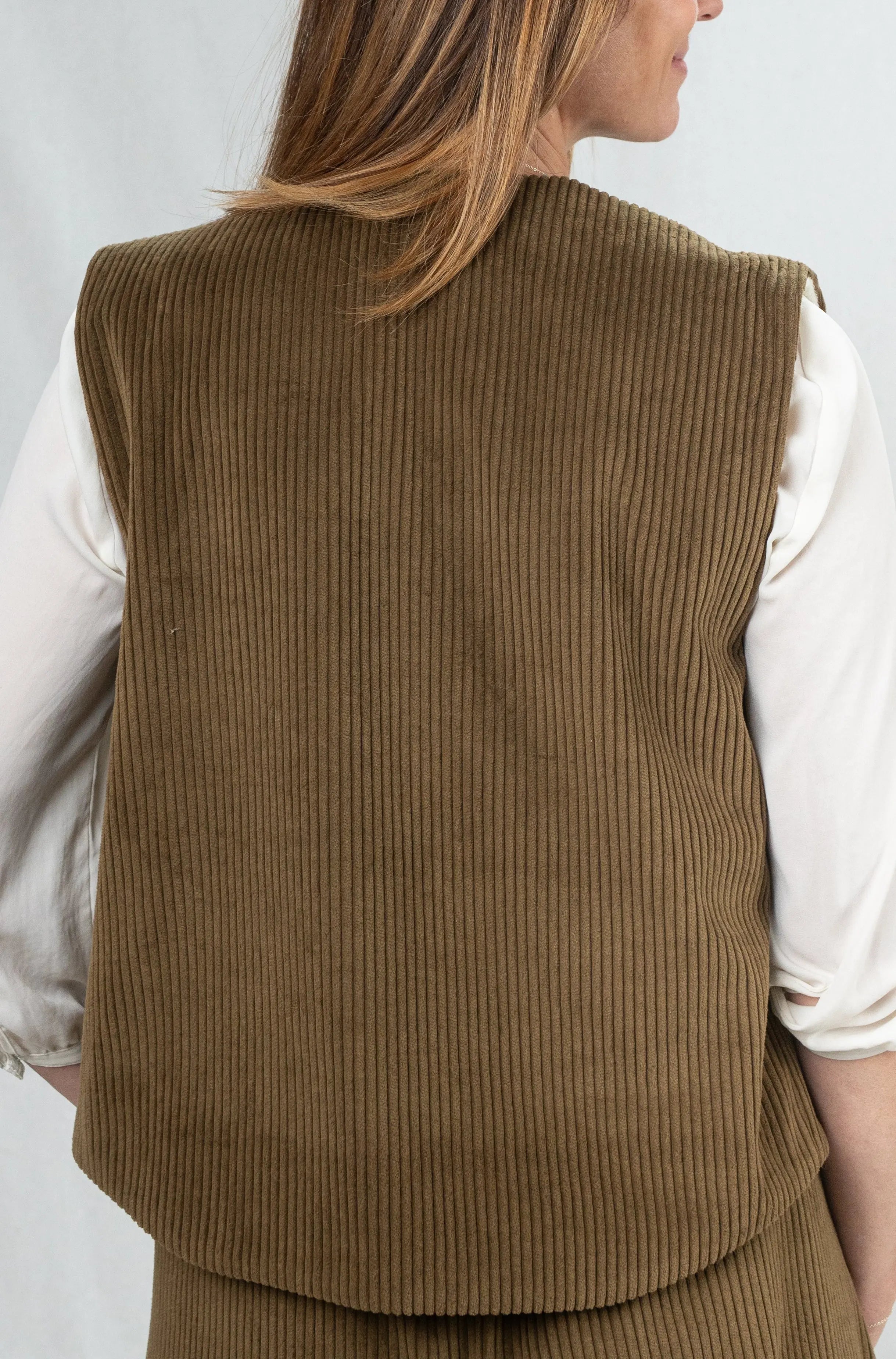 Gilet sans manches Ouessant en velours marron havane, vu de dos, porté avec un pantalon assorti en velours côtelé marron havane, pour un total look inspiré du style tailleur.