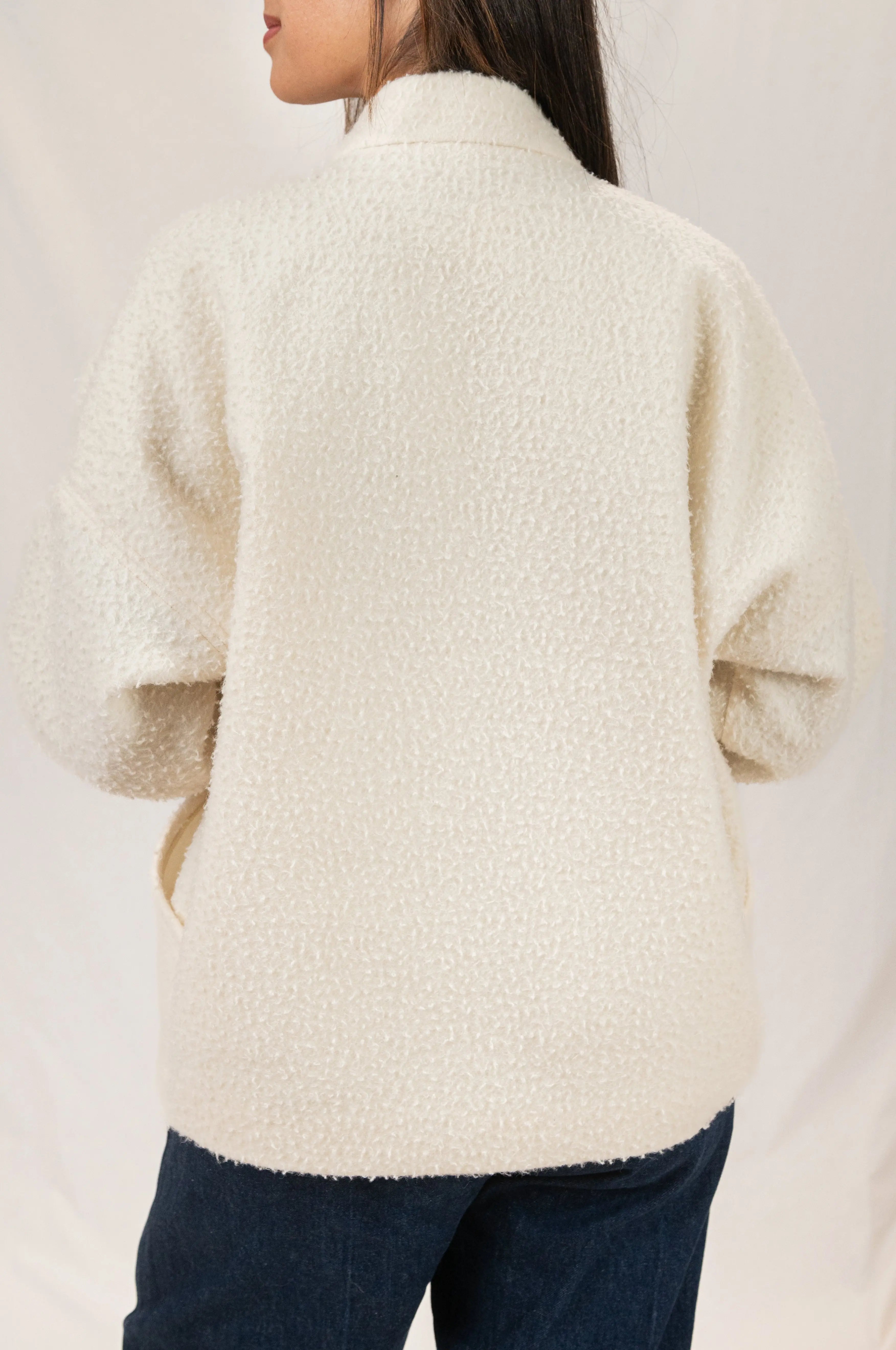 Manteau Cévennes coupe kimono en drap de laine Casentino crème, vu de dos, porté avec un pantalon Sylène en denim, coupe Barrel Leg.