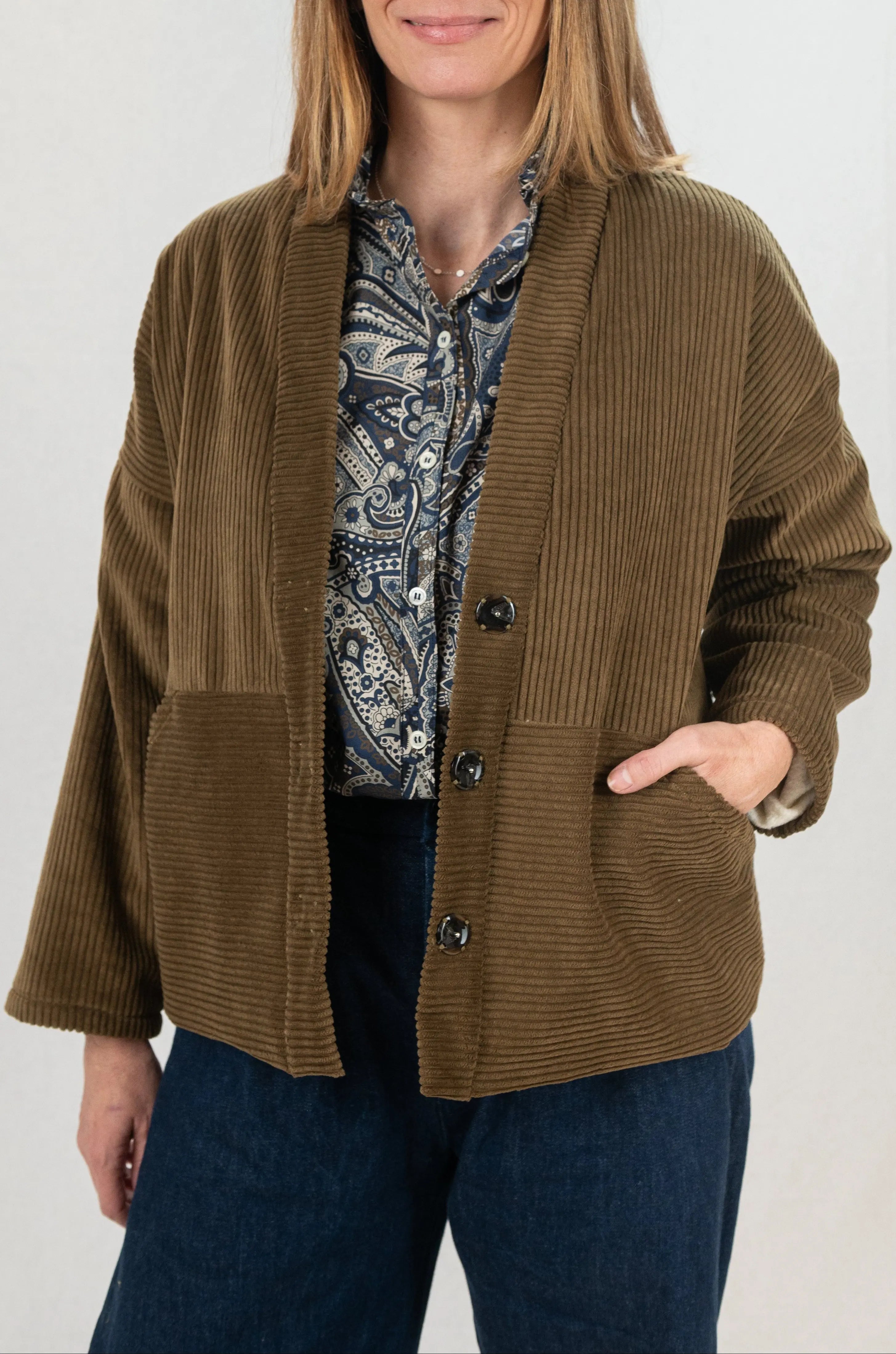 Manteau Cévennes coupe kimono en velours côtelé marron havane, vu de face, porté avec une chemise Narcisse motif paisley cashmere et collier signé A.no.