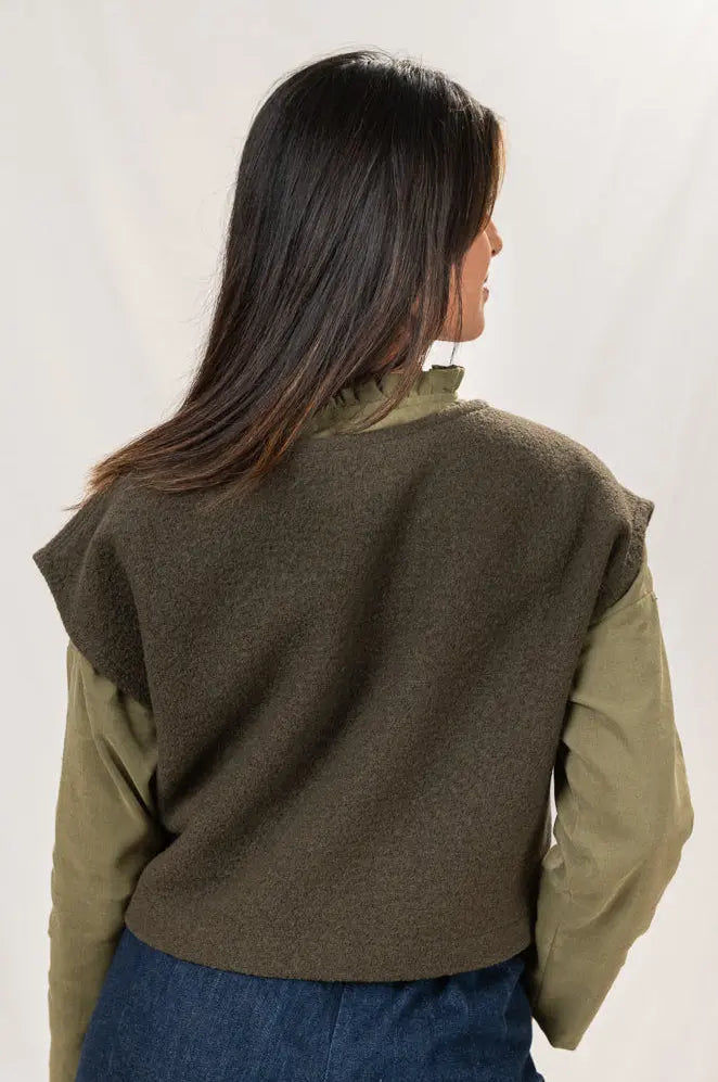 Pull Mousse manches courtes vert forêt en laine bouillie, vu de dos, avec aperçu du col froncé de la chemise Narcisse kaki, porté avec le pantalon Sylène en denim bleu foncé.