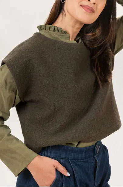 Pull Mousse vert forêt à manches courtes en laine bouillie, vu de profil, porté sur une chemise Narcisse kaki et un pantalon Sylène en denim.